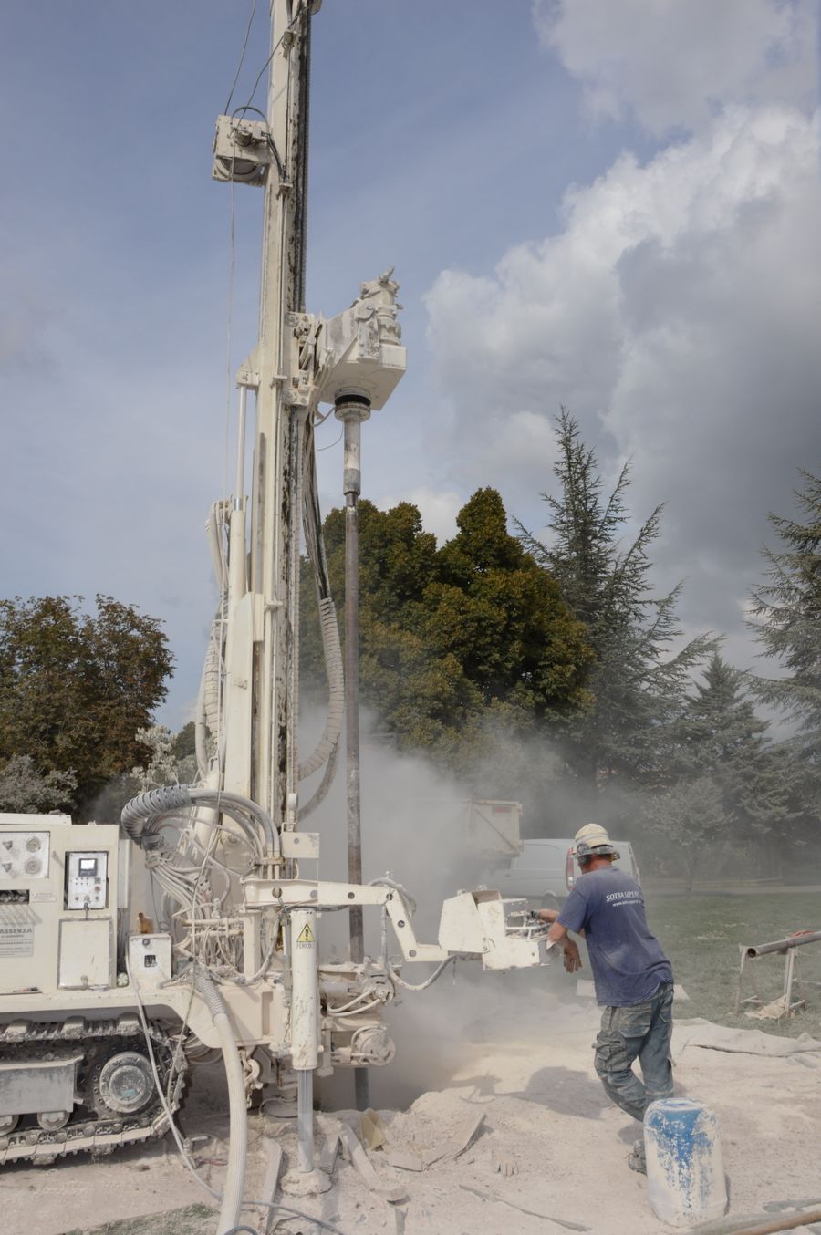 Drilling rig operating in a residential area with trees in the background