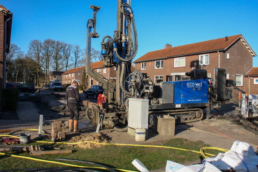 Drilling crew working on a residential street in front of houses